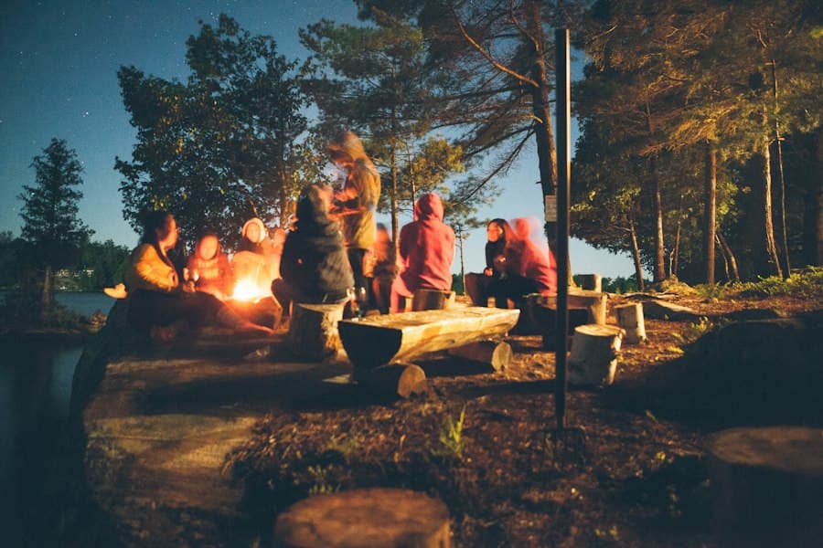 Teenagers sitting around a campfire at dusk