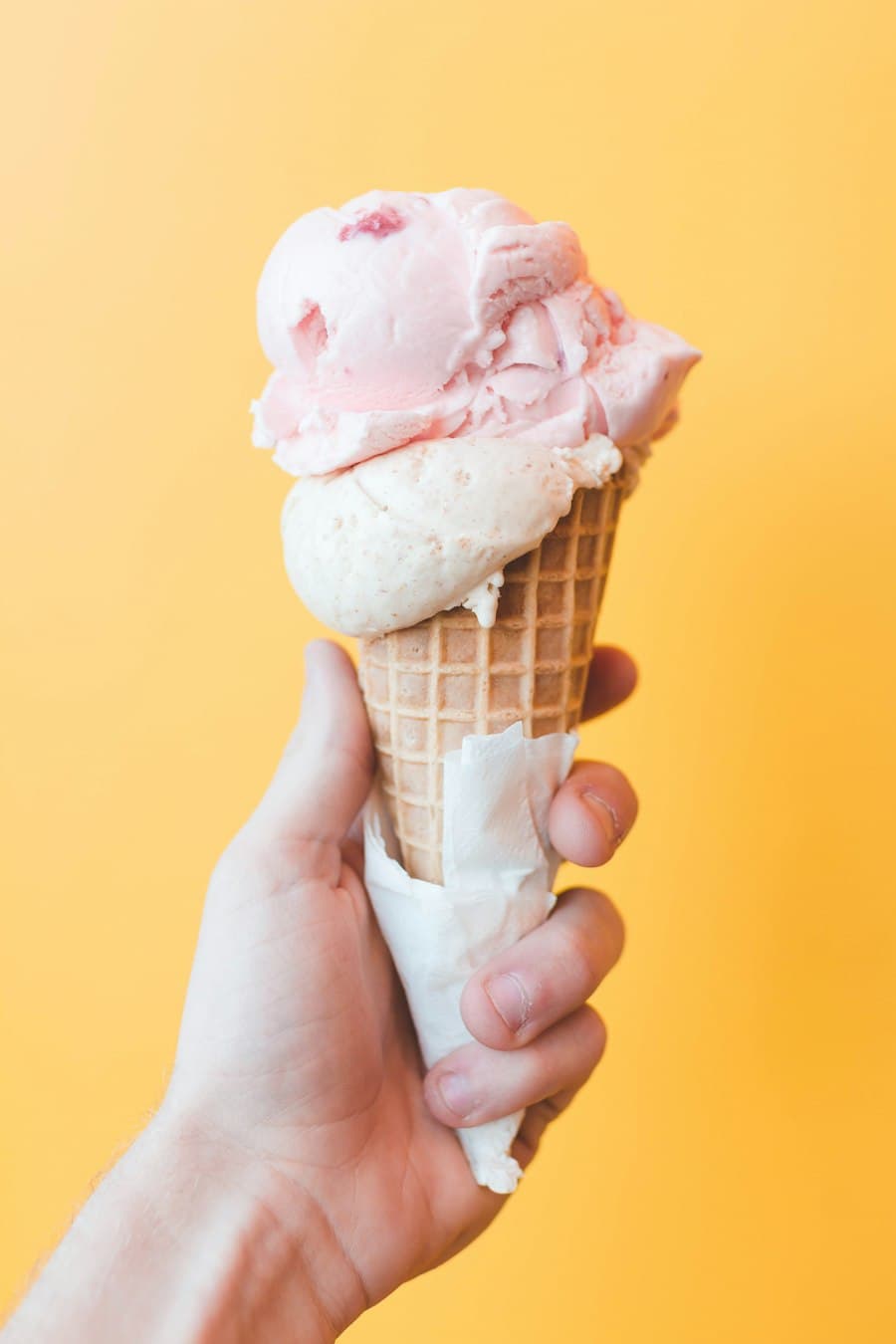 Ice cream cone against a sunny yellow background